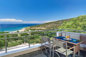 a balcony with a table and chairs and the ocean at Aphrodite of Thassos in Skala Marion