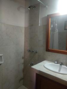 a bathroom with a sink and a shower with a mirror at Casa M in Tilcara