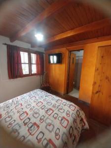 a bedroom with a bed with a comforter on it at Casa M in Tilcara