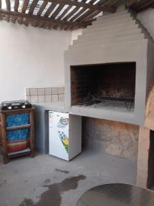 a kitchen with a pizza oven and a refrigerator at Casa M in Tilcara