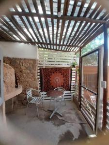 a patio with a table and chairs and a stone wall at Casa M in Tilcara