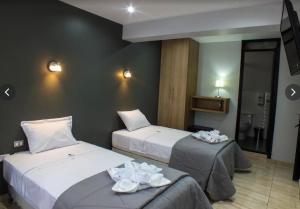 a hotel room with two beds and a television at Hotel Mochiks Trujillo in Trujillo