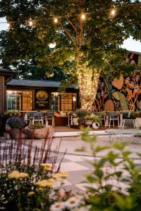 a restaurant with tables and chairs and a tree at UNCOMMONER HOTEL by Reverie Boutique Collection in West Yarmouth