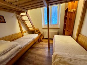 a room with two beds and a window at Chalupa U Potoka in Josefŭv Dŭl