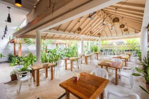 a restaurant with wooden tables and white chairs at Rihiveli Residence Thoddoo in Thoddoo