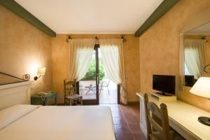 a bedroom with a bed and a desk with a television at Lantana Resort Hotel&Apartments in Pula