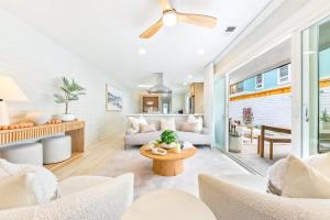 a living room with white furniture and a ceiling fan at Designer Del Mar Escape Beach Dining & Shops in San Diego