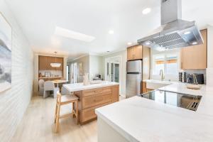 a large kitchen with white counter tops and a kitchen island at Designer Del Mar Escape Beach Dining & Shops in San Diego +23 photos