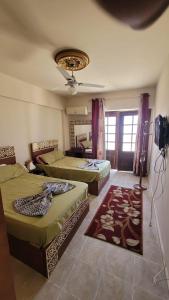 a bedroom with two beds and a ceiling fan at Villa Marsilea in Dawwār Muḩammad Abū Shanab +11 photos