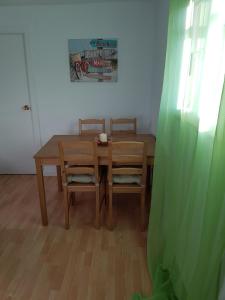 a dining room table with two chairs and a green curtain at Del Rio in Madrid