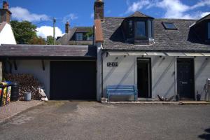 a blue bench sitting outside of a garage at Lily Bank Room in Stonehaven