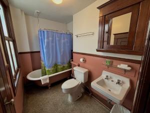 a bathroom with a toilet and a sink and a mirror at Arundel Mansions Hotel in New Westminster +73 photos