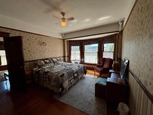a bedroom with a bed and a ceiling fan at Arundel Mansions Hotel in New Westminster