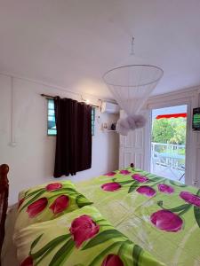 a bedroom with a green bed with flowers on it at Studio Arawak in Deshaies