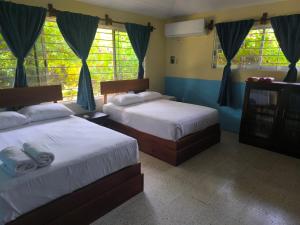 two beds in a bedroom with blue walls and windows at La Morada, una ventana al golfo - Hotel boutique in Monte Gordo +61 photos
