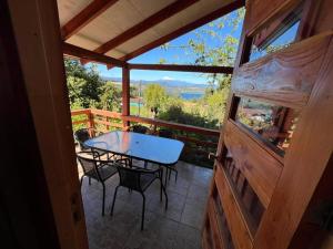 a table and chairs on the porch of a cabin at Cabañas Rayen Lemu in Panguipulli