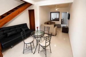 a living room with a glass table and a couch at Chalé Charmoso na Serra de Penedo in Penedo