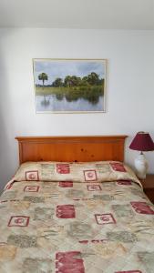 1 cama en un dormitorio con una foto en la pared en Maples Motel, en Orillia