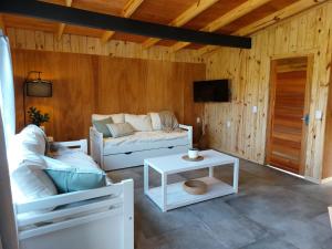 a living room with a couch and a table at Madera y sal Cabañas piriapolis in Playa Hermosa
