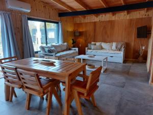 a living room with a wooden table and chairs at Madera y sal Cabañas piriapolis in Playa Hermosa