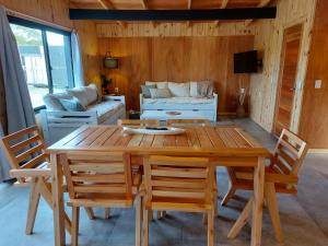 a wooden table and chairs in a living room at Madera y sal Cabañas piriapolis in Playa Hermosa +12 photos
