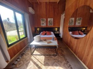 a bedroom with two beds and a large window at Madera y sal Cabañas piriapolis in Playa Hermosa