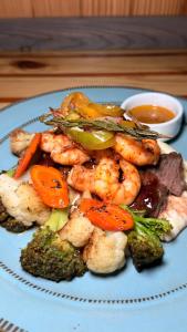 a blue plate of food with shrimp and broccoli at Casa Nova Cabanas in San Pedro +35 photos