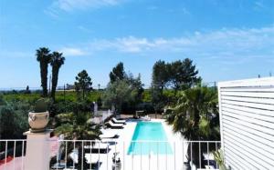 a view of a swimming pool with palm trees at Hotel Residence Noto Marina Relais in Calabernardo