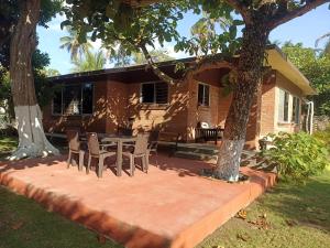 a house with a table and chairs under two trees at La Morada, una ventana al golfo - Hotel boutique in Monte Gordo