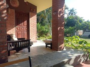 a porch with a wooden door and a bench at La Morada, una ventana al golfo - Hotel boutique in Monte Gordo