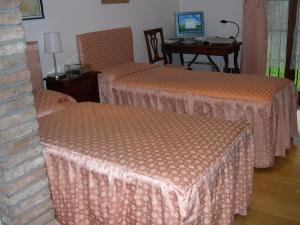 サン・ドナ・ディ・ピアーヴェにあるCa l'oasiのベッド2台とデスクが備わるホテルルームです。
