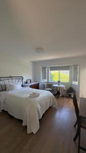 a white bedroom with a bed and a window at Richmond Cozy Place 2 in Richmond