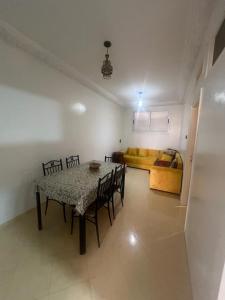 a dining room with a table and chairs and a couch at agadir location vacance aourir plage in Aourir