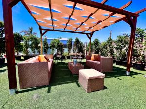 a pergola with chairs and tables on a lawn at Casita Con Encanto in El Palmar