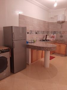 a kitchen with a stainless steel refrigerator and a counter at agadir location vacance aourir plage in Aourir +3 photos