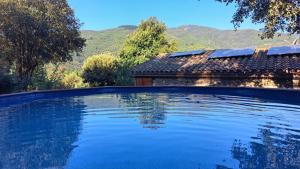 a large swimming pool in front of a house at Masia Casa Nova de n'Illa in Montseny