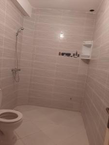 a white bathroom with a toilet and a shower at agadir location vacance aourir plage in Aourir