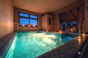 a swimming pool with lights in a house at Elgio' Design Retreat with Etna View Taormina in Taormina