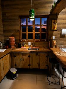 a kitchen with a sink and a window at Chalé Recanto da Cuesta in Botucatu