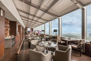 a restaurant with tables and chairs and large windows at Marco Polo Ortigas Manila in Manila
