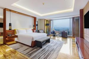a bedroom with a large bed and a large window at Marco Polo Ortigas Manila in Manila