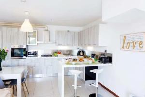 a kitchen with white cabinets and a white counter top at Villa Sereni - 115 in Due Cossani