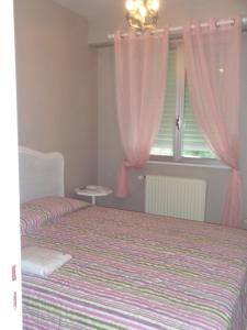 エペルネーにあるLe Saint Vincentのベッドルーム1室(ベッド1台付)、ピンクのカーテン付きの窓が備わります。