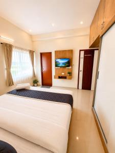 a bedroom with two beds and a flat screen tv at Sai Grand Villas & Hotel Near Bengaluru Airport in Bangalore