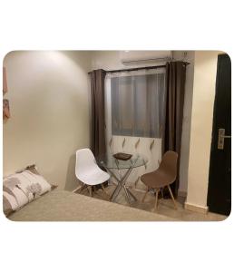 a bedroom with a bed and two chairs and a table at Dakar center studio house in Dakar