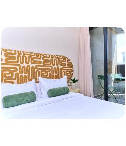a bedroom with a large white bed with green pillows at Dakar center studio house in Dakar