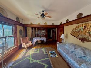 a living room with a couch and a ceiling fan at Arundel Mansions Hotel in New Westminster