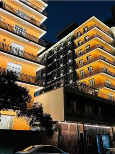 a tall yellow building with cars parked in front of it at Mazar New palaza 