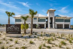 a lost key beach club sign in front of a building at The Palm LK Private Beach Club 100"TV in Pensacola