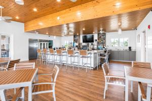 a restaurant with wooden ceilings and tables and a bar at The Palm LK Private Beach Club 100"TV in Pensacola